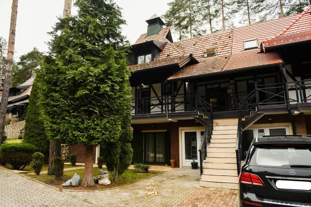 une maison avec une voiture garée devant elle dans l'établissement Apartman Konaci, à Zlatibor