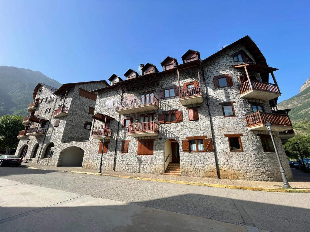 un gran edificio de piedra con balcones en una calle en B21 - Edif. Perramó 1º - Villmor, en Benasque