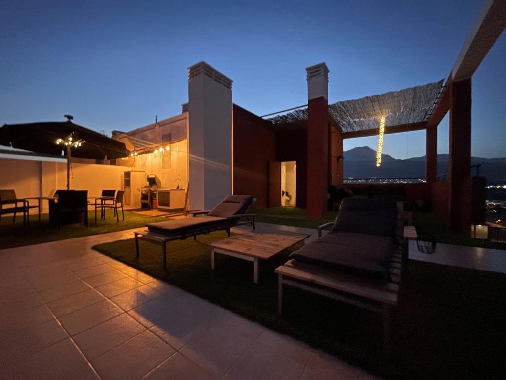 ein Haus mit einer Terrasse mit einem Sofa und einem Tisch in der Unterkunft Atico con terraza de 140 m2 in Benidorm
