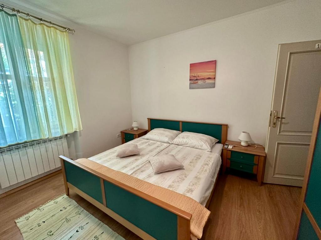 a bedroom with a bed with a green frame and a window at Villa Milada in Portorož