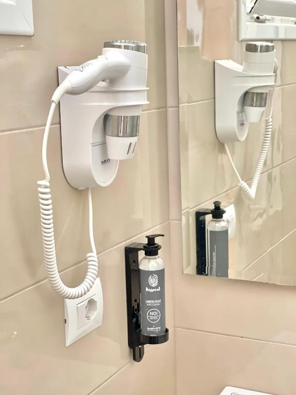 uma casa de banho com um secador de cabelo e um telefone em Hotel Aulona em Sarandë