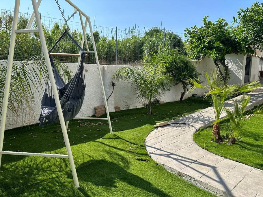 un jardín con una hamaca en un patio en LaMarticata-LikesHome Garden, en Triscina