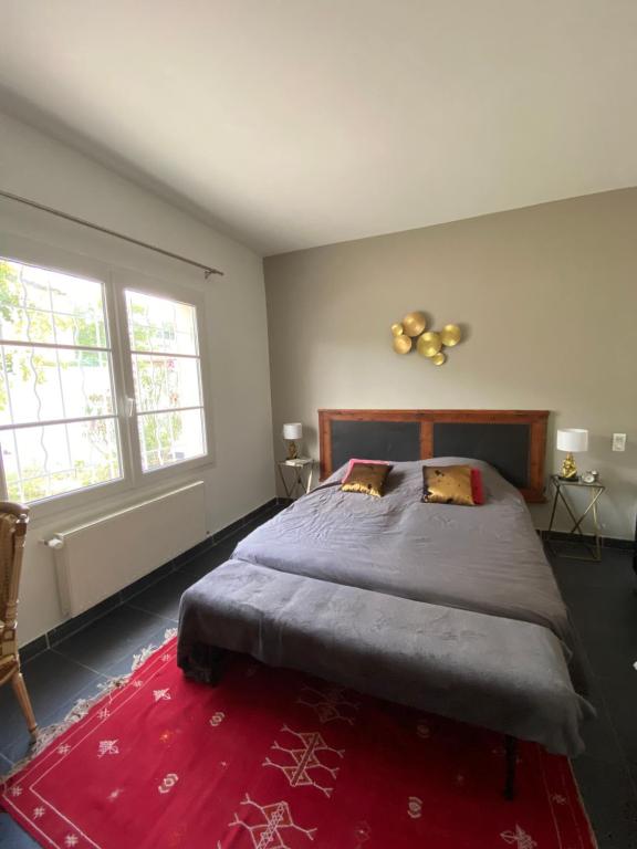 una camera con un grande letto e un tappeto rosso di Proche Avignon au calme a Les Angles Gard