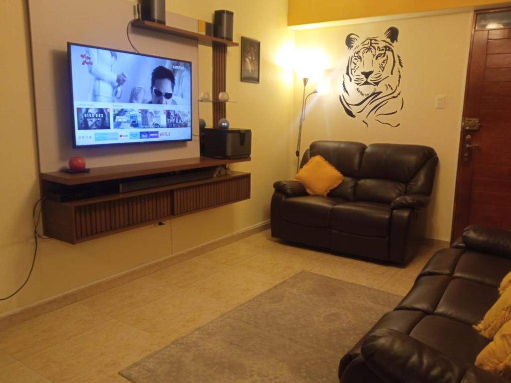 sala de estar con TV de pantalla plana y sofá en Departamento en Huancayo en Huancayo