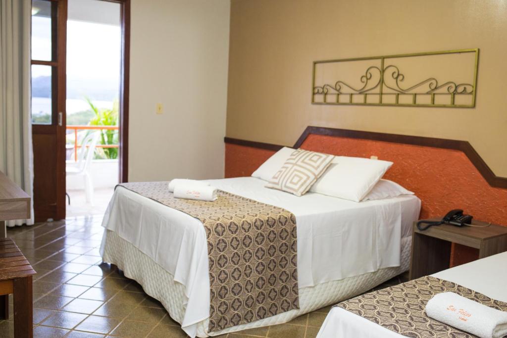 a hotel room with two beds and a balcony at Granville Eco Resort in Rio de Contas