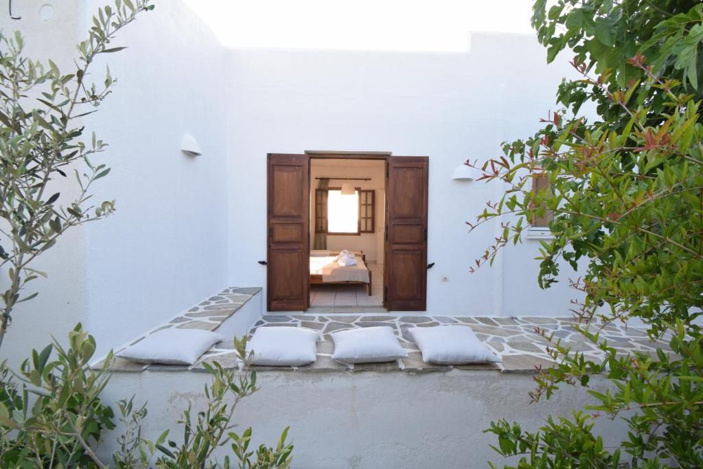 a room with white walls and a bed with white pillows at Sunset Pounda in Pounda