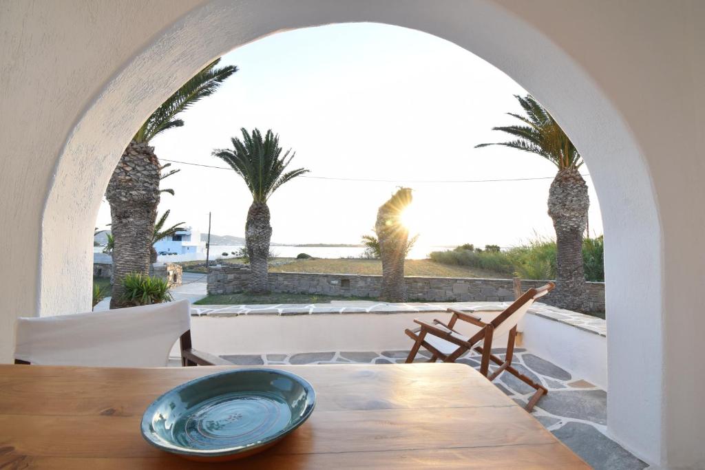 a dining room with a table and palm trees at Sunset Pounda in Pounda