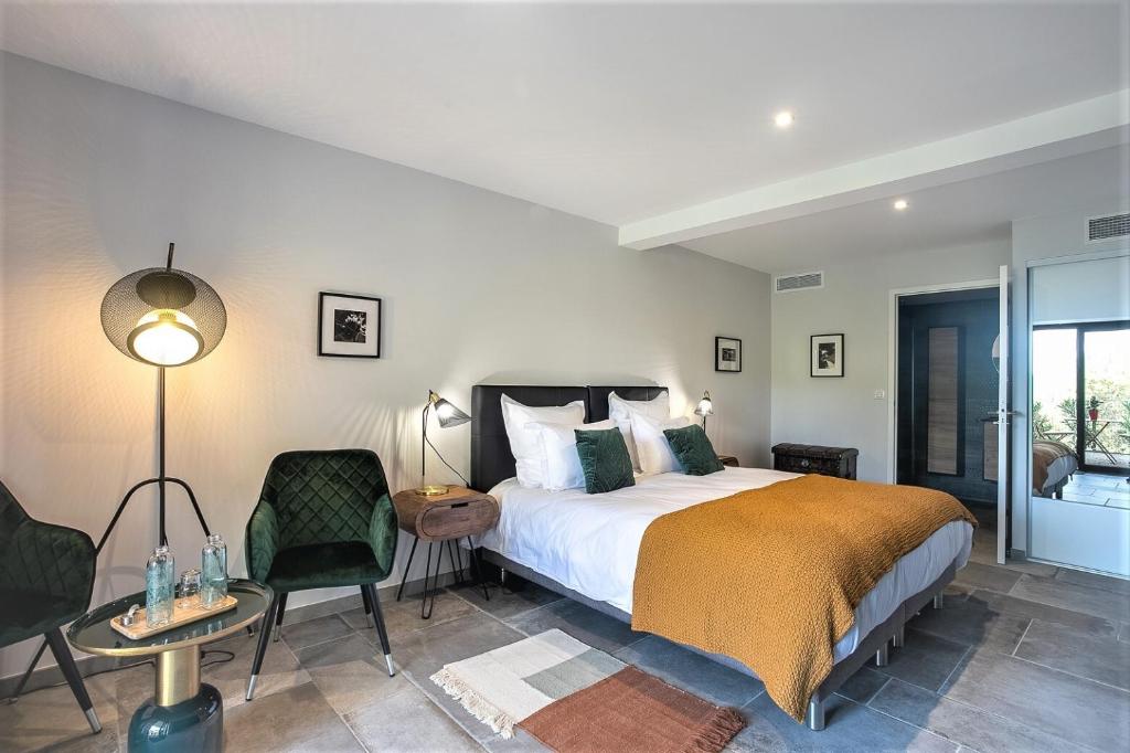 a bedroom with a bed and a table and chairs at Les Hauts du Peireguier in La Motte