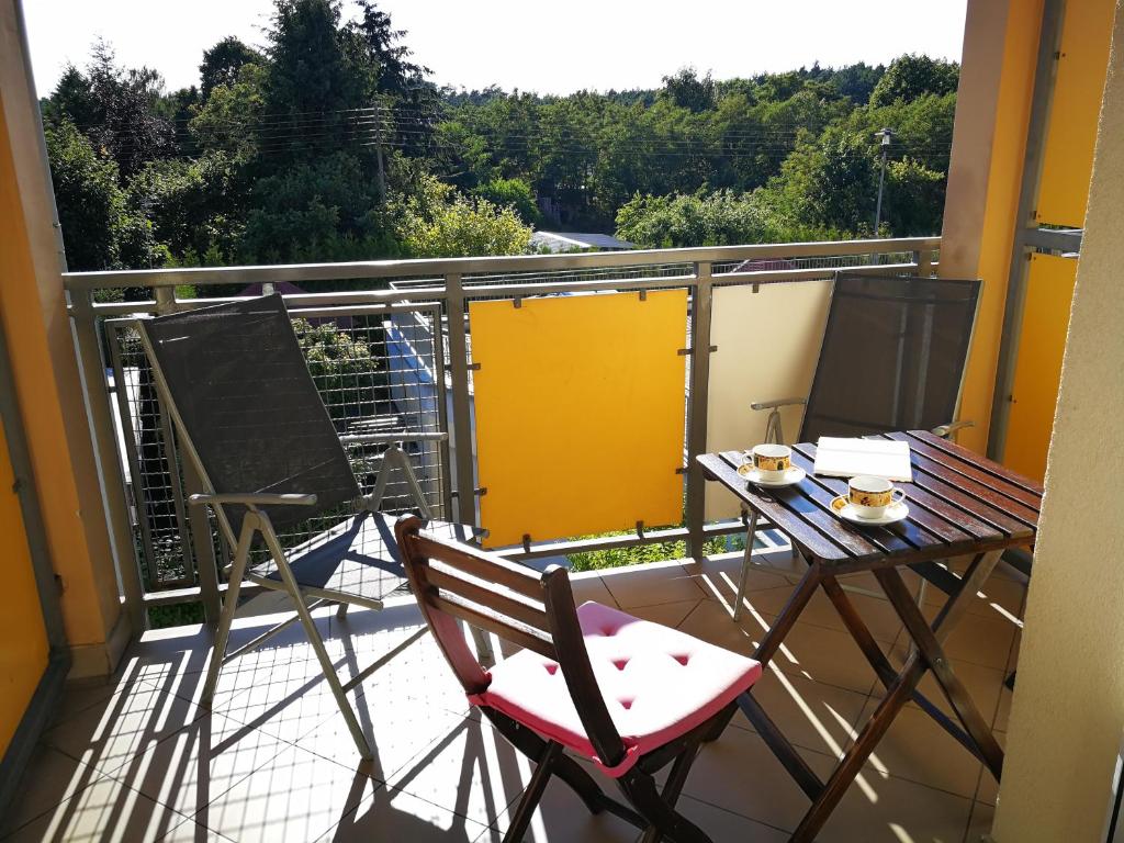 een balkon met een tafel en stoelen op een balkon bij Apartament Majorka - studio in Stegna