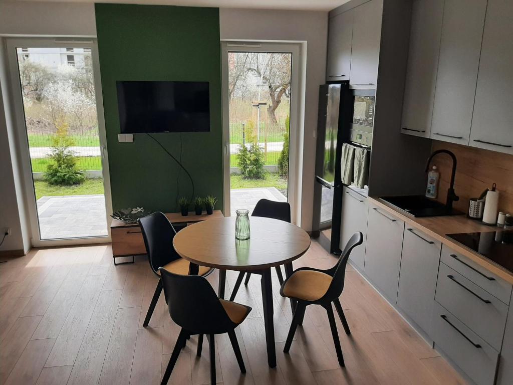 a kitchen with a table and chairs in a kitchen at Apartament na Młyńskiej in Busko-Zdrój