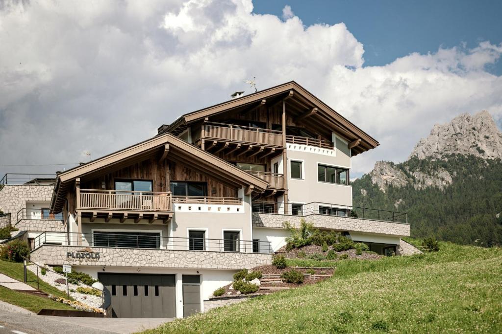 a large house on top of a hill at Luxury Chalet Plazola in Selva di Val Gardena