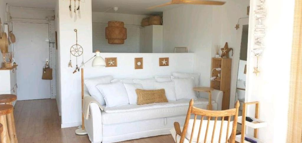 sala de estar con sofá blanco y silla en PRECIOSO APARTAMENTO VISTAS AL MAR en Platja  d'Aro