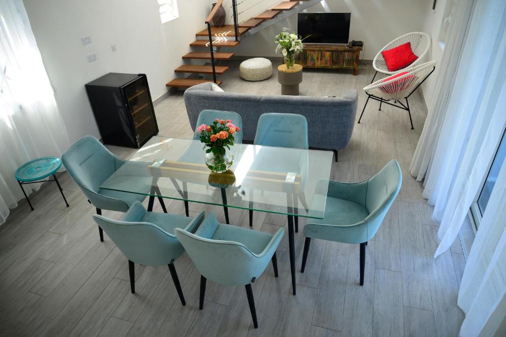 sala de estar con mesa de cristal y sillas en Mahebourg Family Home, en Mahébourg