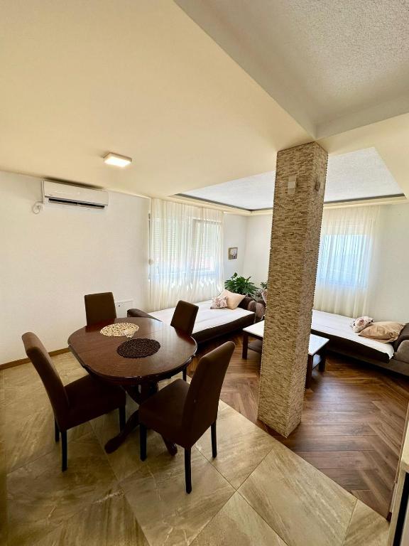 a living room with a table and chairs and a couch at Montenegrina Apartment in Budva