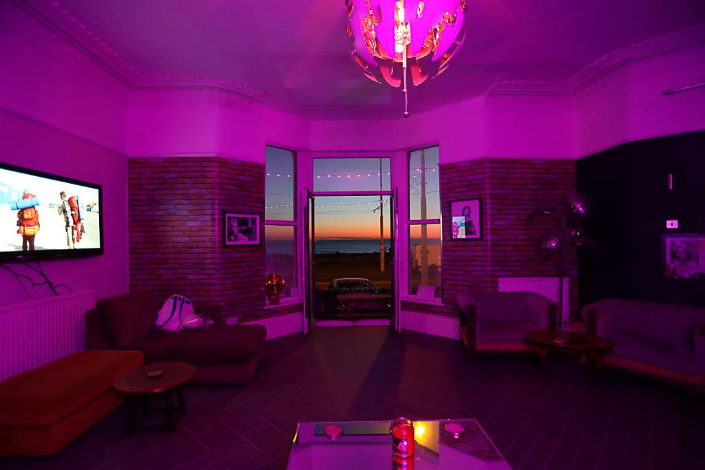 a living room with purple lighting and a tv at Ferny House in Blackpool