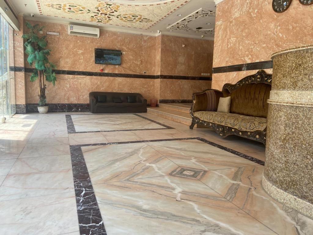 ein Wohnzimmer mit einem Sofa und einem Teppich auf dem Boden in der Unterkunft هدى الحجاز للشقق المفروشة in Mekka