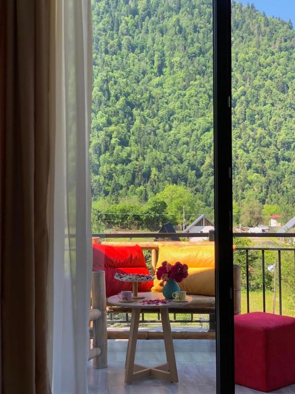 a room with a table and a view of a mountain at Green Mountain Borjomi in Borjomi