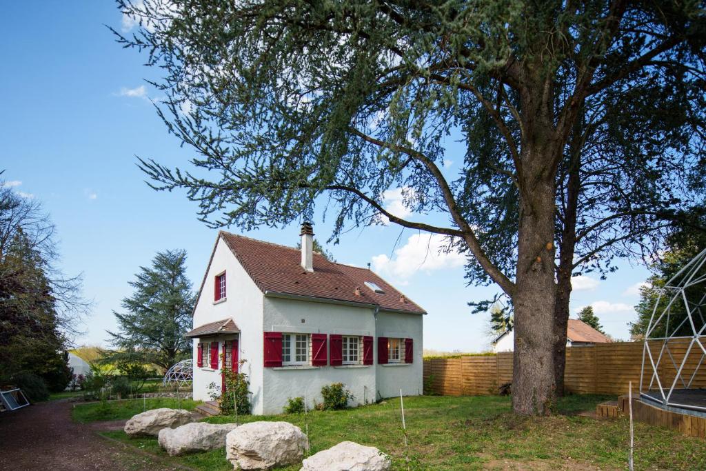 a small white house with red windows and a tree at Maison avec vue sur Loire proche de Chambord in Saint-Dyé-sur-Loire
