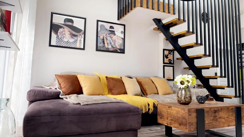 a living room with a couch and a spiral staircase at Gite & Spa Au pommier fleuri in Drusenheim