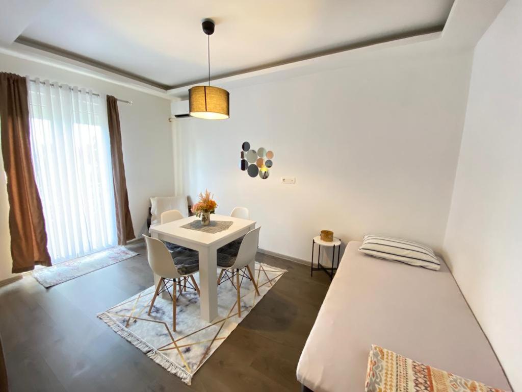 1 dormitorio con 1 cama, mesa y sillas en Home Mia 2 bedroom apartment, en Podgorica