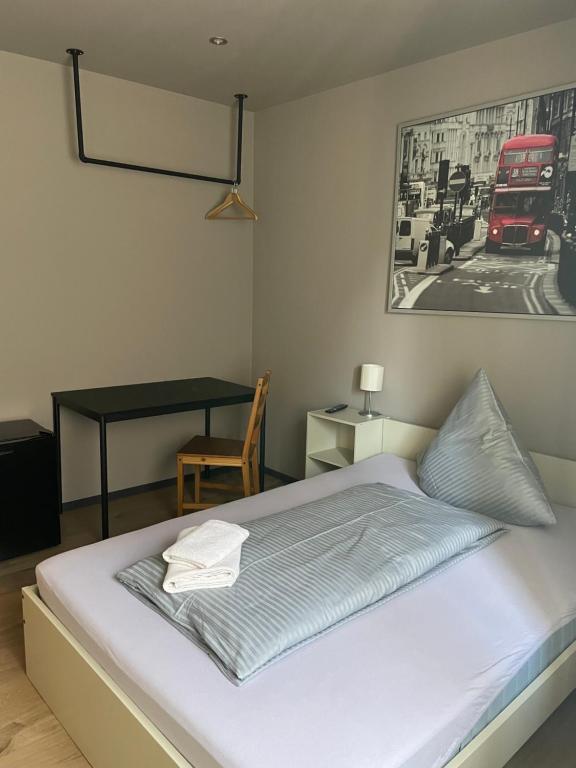 a bedroom with a bed with a desk and a picture of a bus at Alpha Fremdenzimmer in Fürth