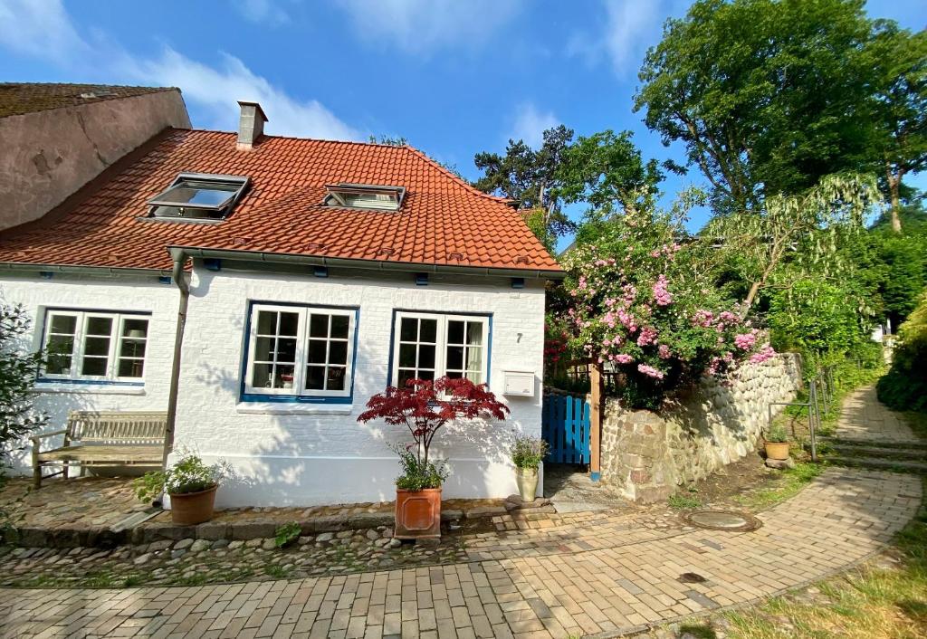 ein kleines weißes Haus mit rotem Dach in der Unterkunft Fischerhaus Blankenese in Hamburg