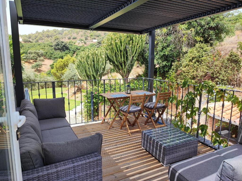 un patio con mesa y sillas en una terraza en Penthouse Apartment, Cortijo Fruitful HIlls, en Málaga