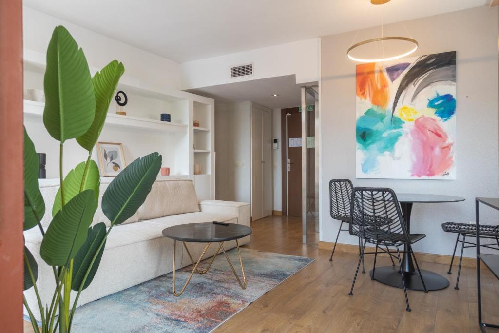 a living room with a couch and a table and chairs at Aparthotel ARDMADRID Centro in Madrid