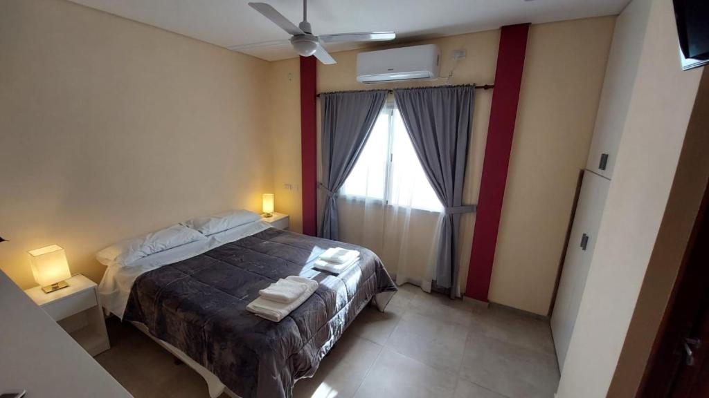 ein Schlafzimmer mit einem Bett, zwei Lampen und einem Fenster in der Unterkunft Departamento monoambiente Necco Apart in Corrientes