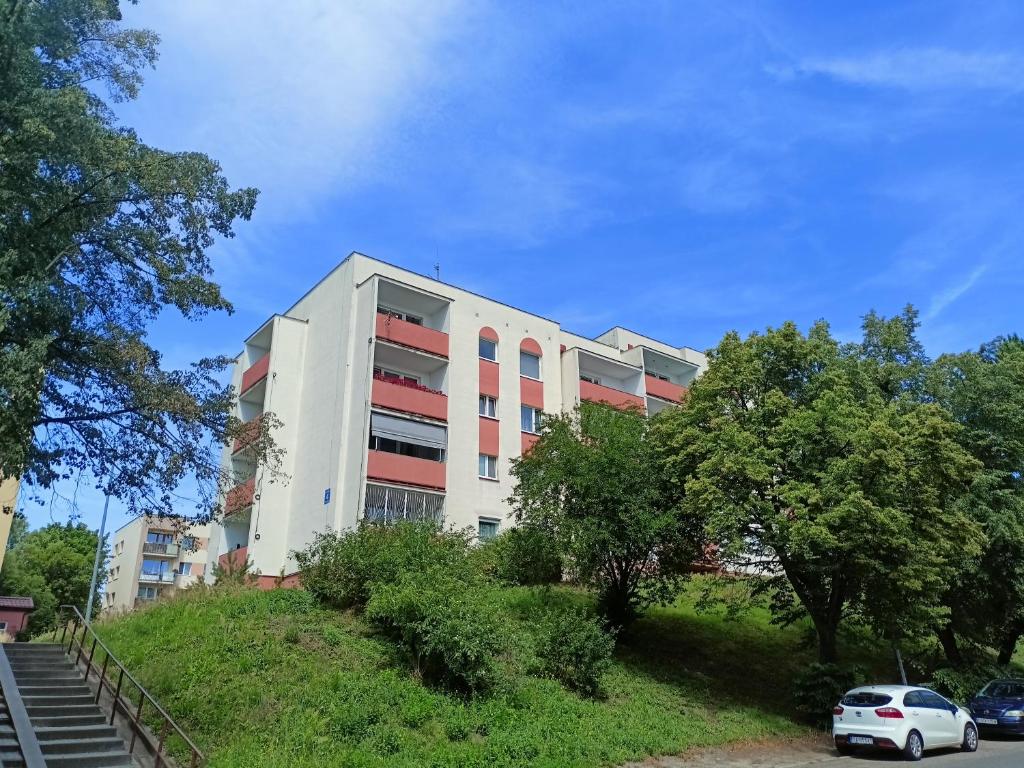 a building on a hill with cars parked in front of it at Apartament Sucharskiego in Gdynia