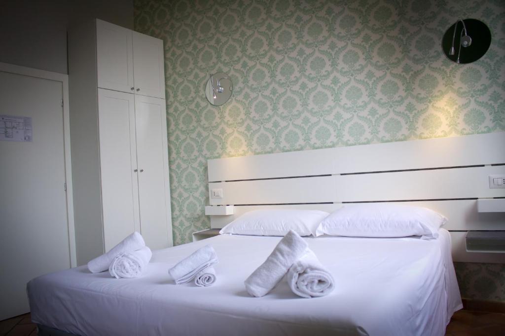 Un dormitorio con una cama blanca con toallas. en IL MERCATO CENTRALE B and B, en Florencia