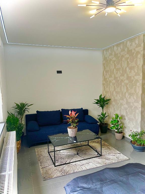 a living room with a blue couch and a table at Modernes Apartment am Marktplatz in Wesel