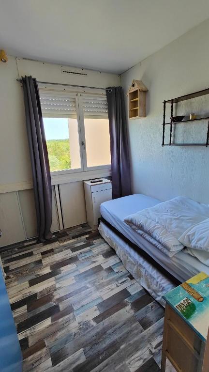 une petite chambre avec un lit et une fenêtre dans l'établissement Studette à 100m de la plage, à Saint-Jean-de-Monts