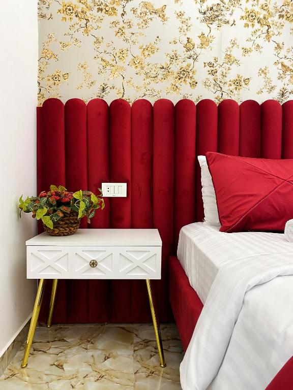 Shirbakyan Boutique Hotel & Apartments في يريفان: جدار مبطن احمر في غرفة النوم مع سرير