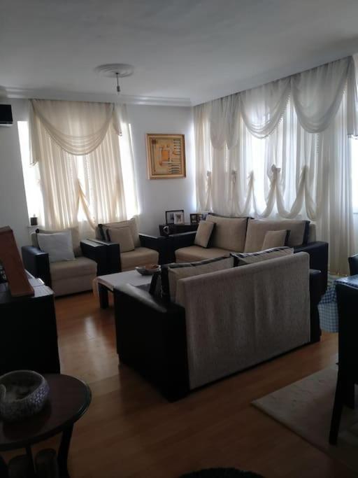 a living room with couches and tables and windows at Cozy home in the center of Antalya in Antalya