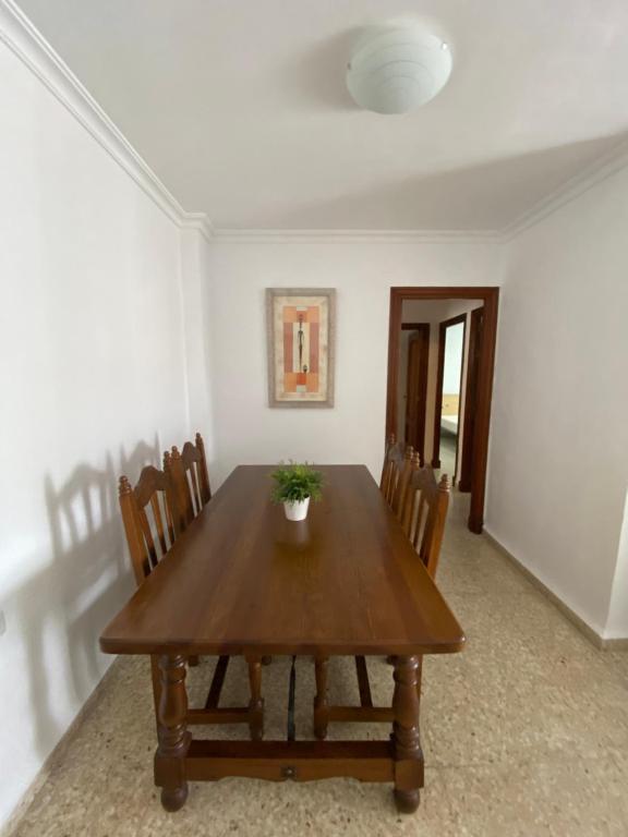 a dining room with a wooden table and chairs at Piso en la puntilla in El Puerto de Santa María