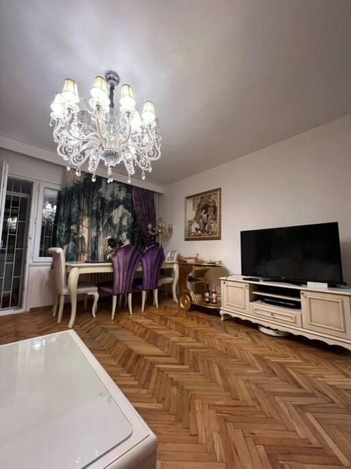 a living room with a television and a chandelier at Lüx gösterişli mükemmel lokasyon in Istanbul