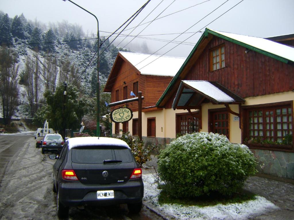 a car parked in front of a building with a clock at Hosteria Cumelen in San Martín de los Andes