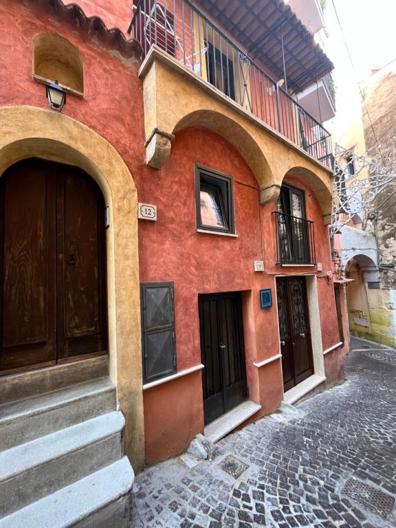 un edificio rosso con archi su una strada di Cisternone Suites a Formia