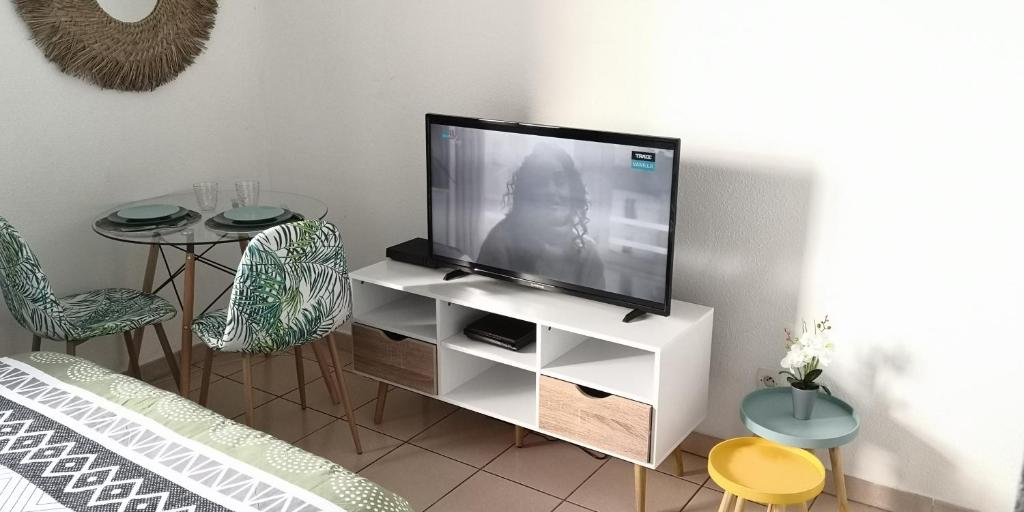 ein Wohnzimmer mit einem TV in einem weißen Unterhaltungszentrum in der Unterkunft Studio équipé Clim TV Wifi in Saint-Denis