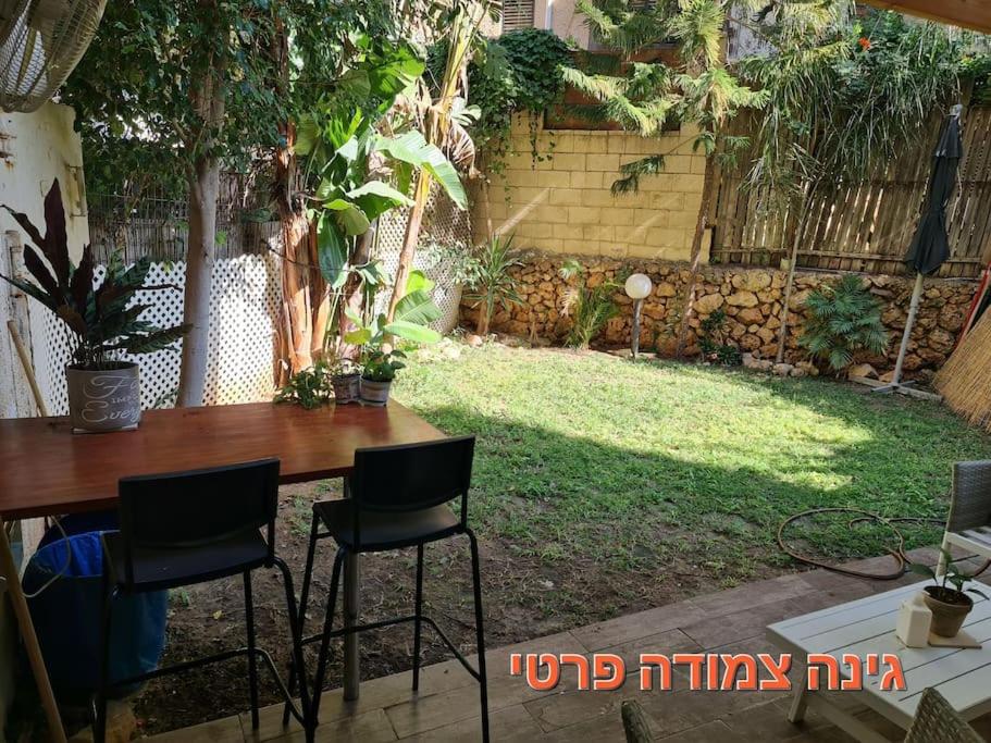 a table and chairs in a backyard with a yard at יחידת דיור (חדר וחצי) - גינה פרטית, חנייה חופשית ! in Herzliya