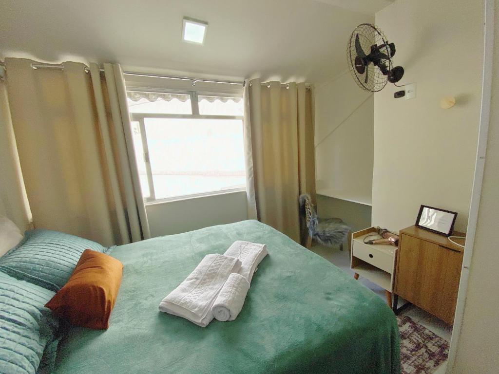 a bedroom with two towels on a bed with a window at Charme Copa Retreat próximo ao Copacabana Palace in Rio de Janeiro