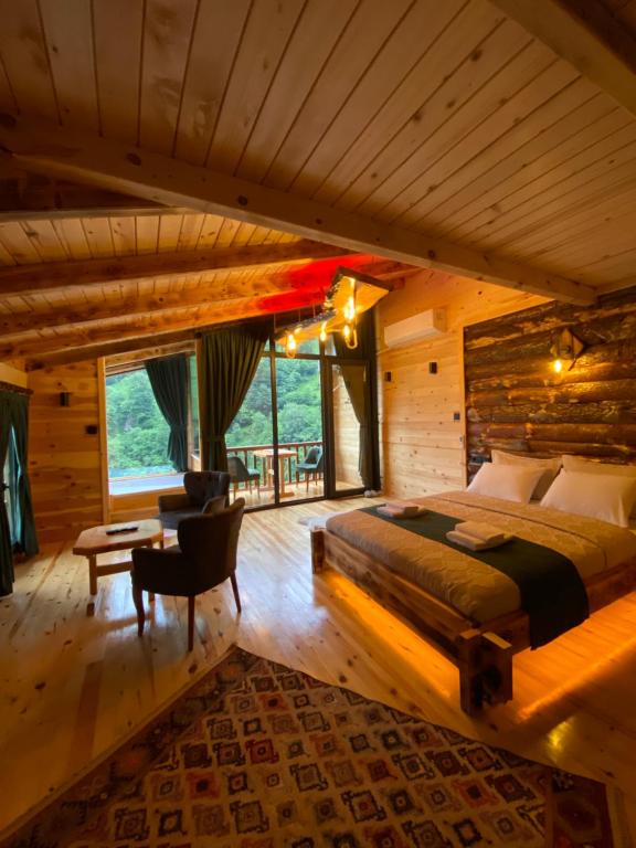Un dormitorio con una cama grande en una cabaña de madera. en Morci Suit Villa, en Çamlıhemşin
