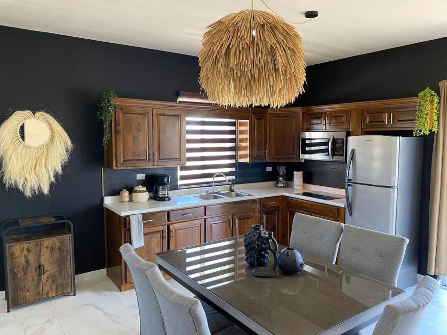 uma cozinha com uma mesa com cadeiras e um frigorífico em Urban Hotel Ancla Suite 10 - 3 Bedroom 2 Bathroom em Puerto Peñasco