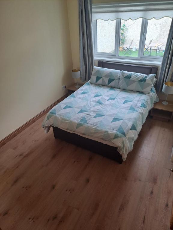 a bed in a bedroom with a wooden floor at Willows Retreat in Dublin