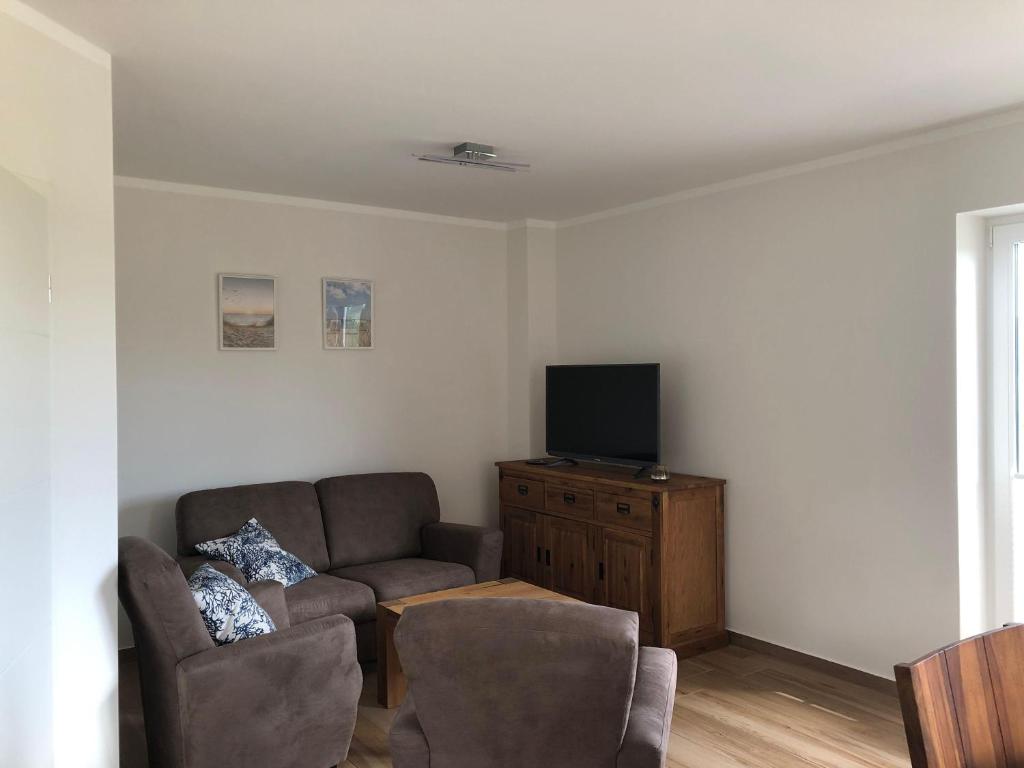 sala de estar con sofá y TV de pantalla plana en Ferienhof-Micheel, en Gammendorf