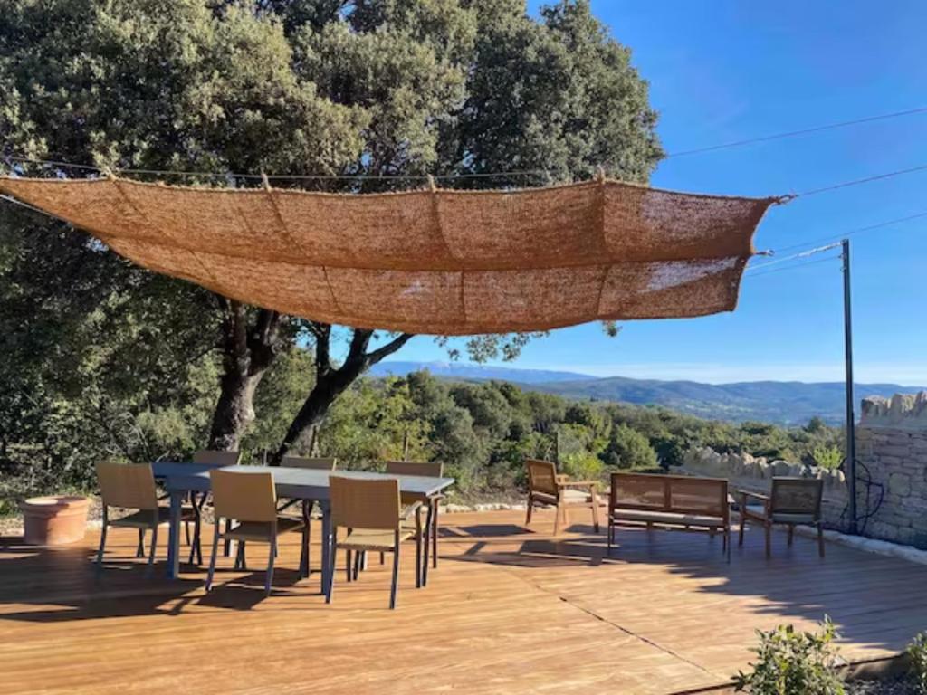 un filet suspendu au-dessus d'une table et de chaises sur une terrasse dans l'établissement La Gardette, Gordes, vue panoramique Ventoux, à Gordes
