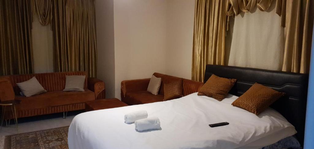 um quarto de hotel com uma cama e duas cadeiras em Lovely Specious 2 bedroom suite apartment Near IST Airport Shuttle option em Arnavutköy