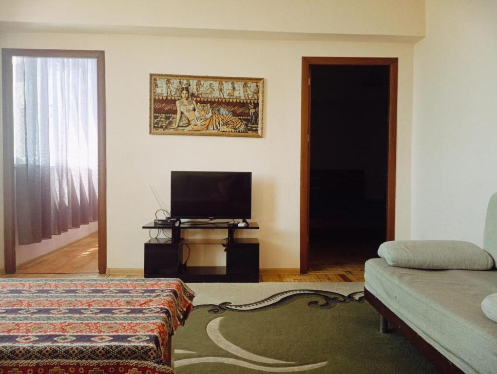 - un salon avec un lit et une télévision dans l'établissement City Center Cozy Apartment Tigran Mets, à Erevan