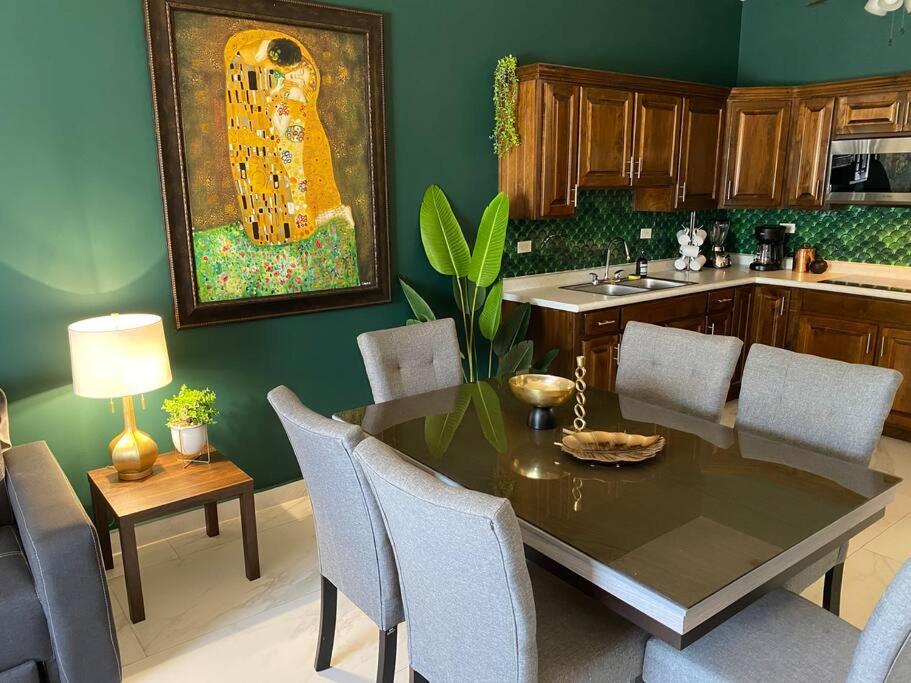 una cocina con mesa, sillas y una pintura en Ancla Suite 9 - Urban Hotel en Puerto Peñasco